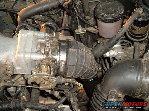 Engine bay detail showing throttle body, intake hose, and brake fluid reservoir