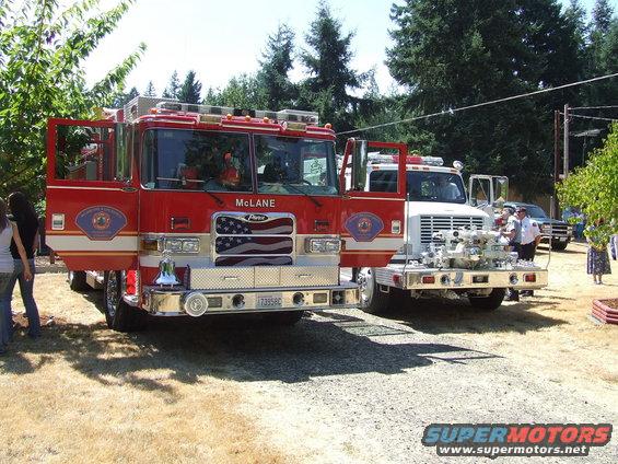 Red fire truck with doors open, American flag grille, and 'McLane' text