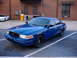 1998 Ford Crown Victoria - Blue Ford Crown Victoria police car parked in a lot with a white Chevrolet Camaro behind it.