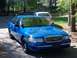 1998 Ford Crown Victoria - A blue sedan is parked outside with another vehicle in the background.