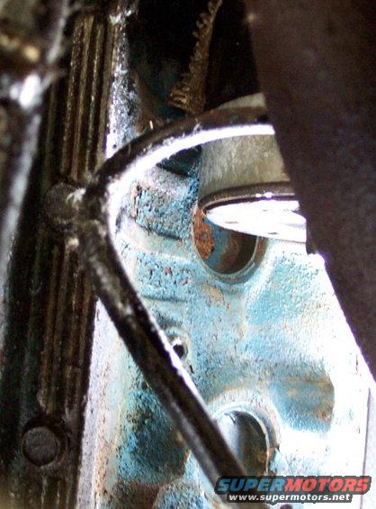 Close-up of a blue engine block with rust spots and some metal components