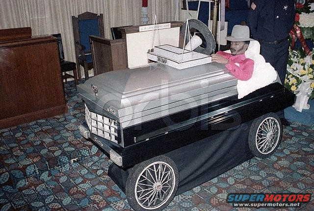 Coffin on wheels with a mannequin dressed in pink