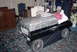 2000 Ford Crown Victoria - A custom coffin designed to resemble a car, complete with wheels and a mannequin figure.
