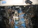 1966 Ford Ranchero - Engine bay view of a 1966 Ford Ranchero, highlighting the blue V8 engine and carburetor. A label is visible on the firewall.