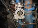 1966 Ford Ranchero - A close-up view of a vehicle's engine, focusing on the carburetor and a blue manifold with visible text and rust.