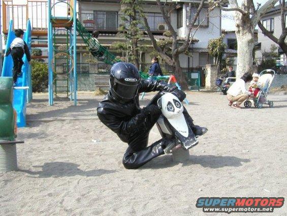 Person in motorcycle gear on panda ride at playground