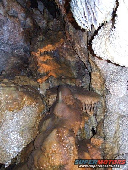 Cave interior with stalactites and stalagmites, water features