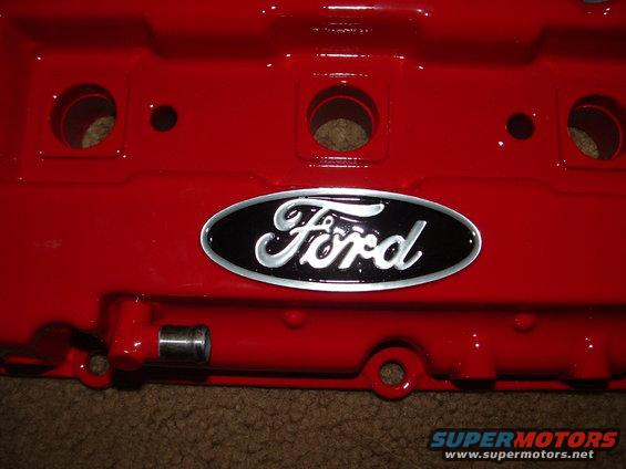Red Ford valve cover with black and silver oval Ford logo