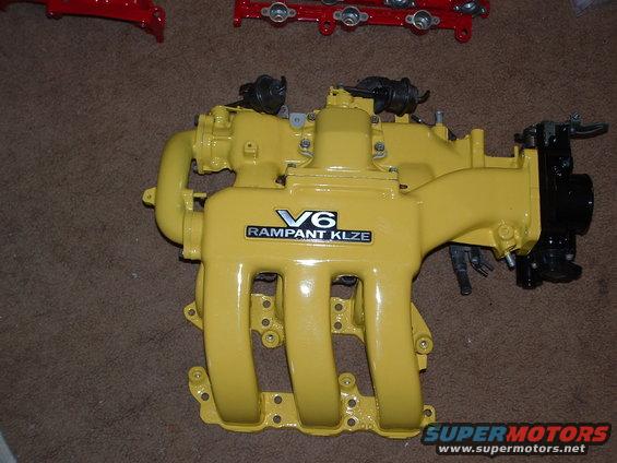 Yellow V6 intake manifold with "V6 RAMPANT KLZE" label. Red parts are visible in the background