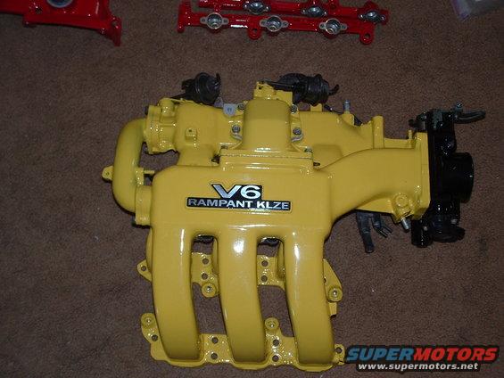 Yellow V6 RAMPANT KLZE intake manifold with black accents, on a brown carpet