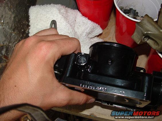 Black throttle body with visible part number 13400-8481, held by a hand