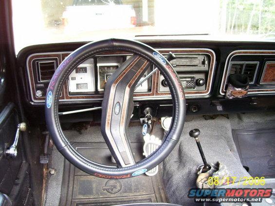 Interior shot of a truck's dashboard and steering wheel. Has a floor shifter and a radio