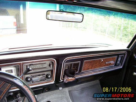 1979 Ford Bronco dashboard with wood grain trim, aftermarket radio, and Ford steering wheel
