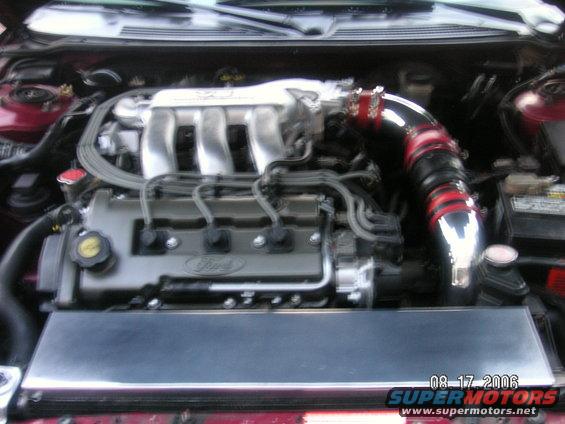 1993 Ford Probe engine bay with aftermarket intake. Ford logo visible on valve cover