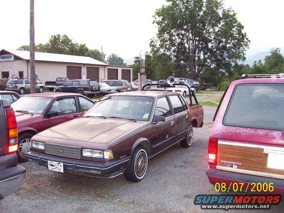 Brown station wagon with custom roll cage and exhaust stack