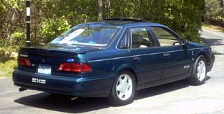 1993 Ford Taurus sedan, rear quarter view, dark blue paint, sunroof