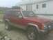 1992 Jeep Cherokee - This 1992 Jeep Cherokee features a roof rack with a cargo box, and a two-tone silver and red body.