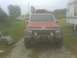 1992 Jeep Cherokee - Front view of a red 1992 Jeep Cherokee parked outdoors with a roof rack.