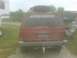 1992 Jeep Cherokee - Rear view of a red Jeep Cherokee with a spare tire mounted on the roof rack and a custom sticker on the back window.