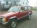 1992 Jeep Cherokee - This red 1992 Jeep Cherokee SUV is shown from a 3q-front angle.