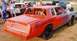 1966 Ford Fairlane - A modified car, likely for racing, sits on a dirt track with other vehicles in the background.