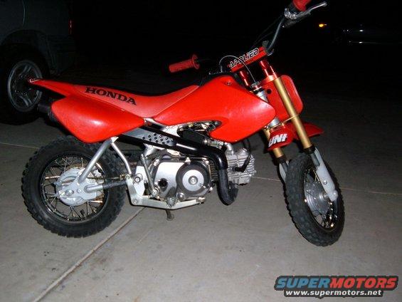 Red Honda dirt bike with gold front forks and black handlebars