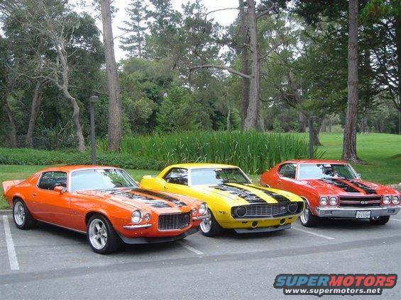 Orange 1970 Chevrolet Camaro parked next to yellow and red muscle cars