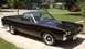 1969 Ford Ranchero - This 1969 Ford Ranchero features a dark brown finish, a prominent hood scoop, and classic mag wheels.