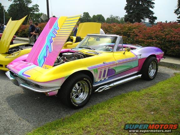 Custom painted 1965 Corvette convertible with hood open, another yellow car behind it