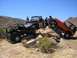 1979 Chevrolet C/K Pickup - Multiple off-road vehicles are seen traversing a rocky landscape on a sunny day.