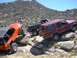 1979 Chevrolet C/K Pickup - Three off-road vehicles navigate a challenging rocky trail under a clear blue sky.