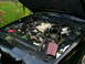 2003 Mercury Marauder - Engine bay of a 2003 Mercury Marauder features a V8 engine and an aftermarket cold air intake system.