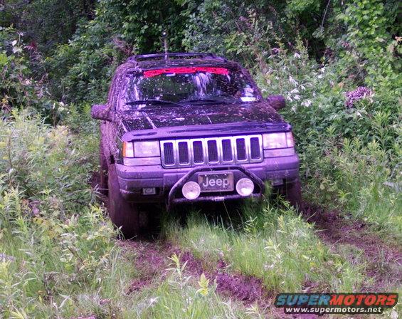 Black Jeep Grand Cherokee stuck in mud, front view