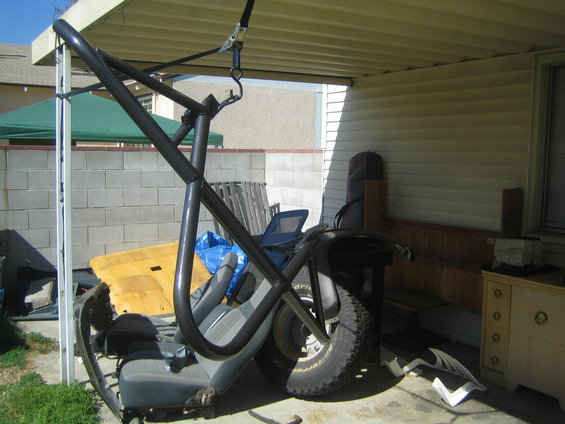 Vehicle roll cage and seats are disassembled and stored under a carport