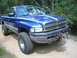 1990 Ford Bronco - This blue Dodge Ram pickup truck is equipped with off-road tires and a winch for terrain.
