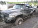 1990 Ford Bronco - This black pickup truck is deeply stuck in mud, with another vehicle visible in the background.