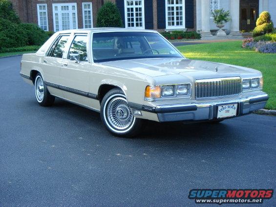Tan 1990 Mercury Grand Marquis sedan, front 3/4 view. Chrome grille and wire wheels