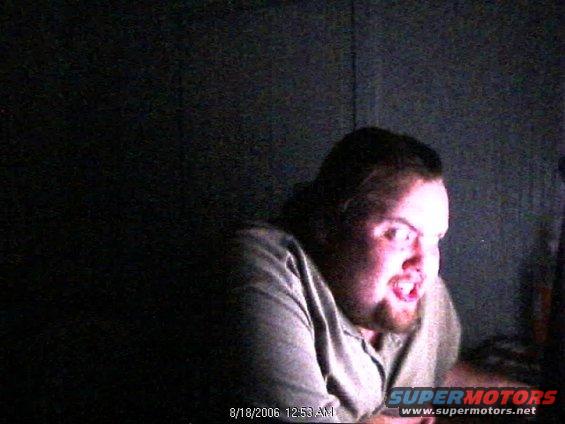 man with beard and short hair looking intensely at a screen, with text overlay showing date and time