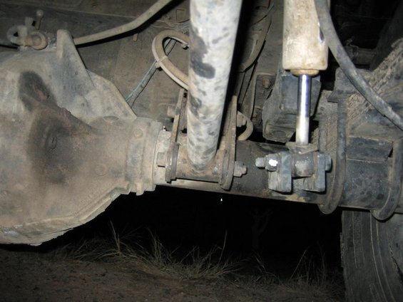 Rear axle housing, shock absorber, and suspension linkage on a vehicle