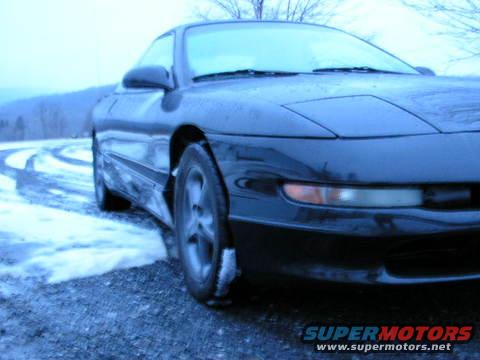 1993 Ford Probe on a snowy road, front 3/4 view. Watermark reads SUPERMOTORS