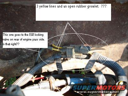 Close-up of engine wiring harness connectors with yellow wires and a black rubber grommet