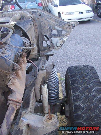 1978 Ford Bronco chassis with front suspension and tire, showing rust and wear