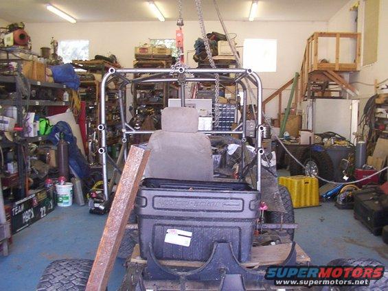 Roll cage construction around a vehicle seat in a garage