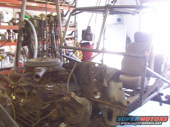 Off-road vehicle chassis with engine and seat in a workshop