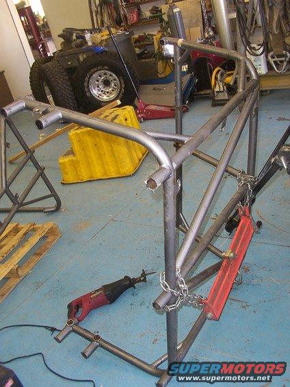 Metal roll cage frame under construction with a reciprocating saw and chains