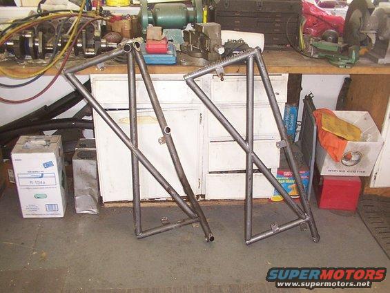 Two metal frames leaning on a workbench in a workshop
