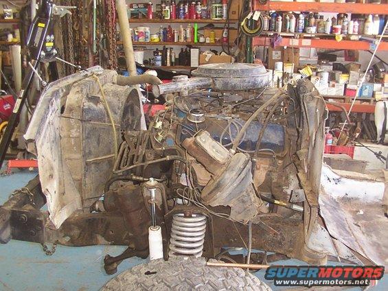 Engine, radiator, and front suspension parts of a vehicle in a garage