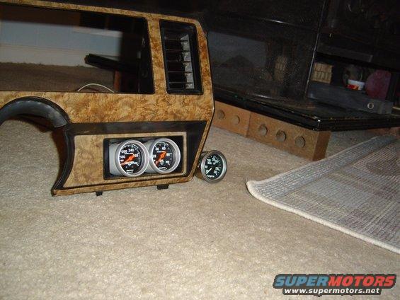 Dashboard trim piece with two gauges installed, plus a third gauge to the side