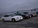 1995 Ford Taurus - Multiple Ford Tauruses are parked in a row near the water under a cloudy sky.