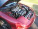 1993 Ford Probe - The V6 engine of a red 1993 Ford Probe is visible with the hood open.